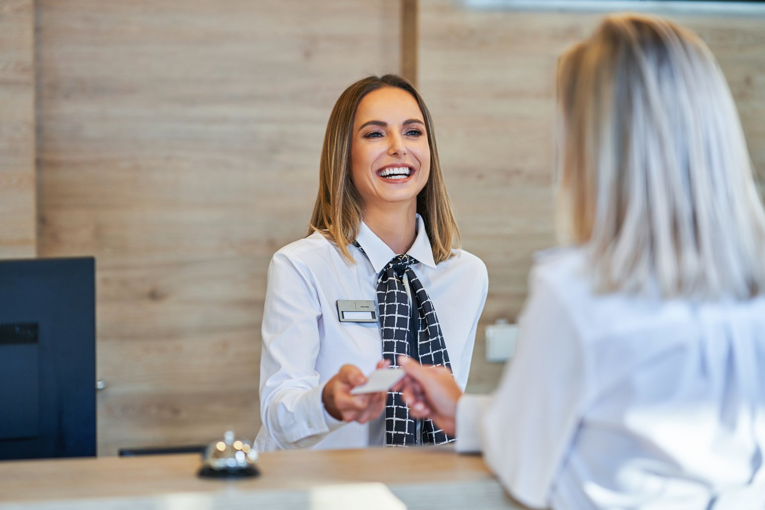 Receptionist and Woman at a Hotel Front Desk